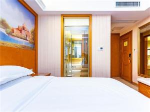 A bed or beds in a room at Vienna Hotel Guizhou Bijie Chuangmei Century City