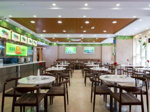une salle à manger avec des tables et des chaises dans un restaurant dans l'établissement Vienna Hotel Shenzhen Yantian Alley, à Shenzhen