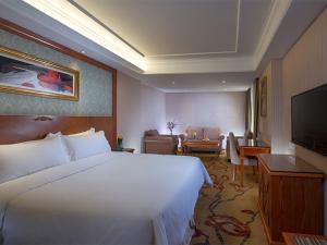 Una habitación de hotel con una cama grande y un televisor. en Vienna Hotel Mix City, en Shenzhen 4 fotos más