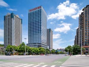 a large tall building in a city with a street at Vienna International Hotel Hunan Chenzhou Qingnian Avenue in Chenzhou