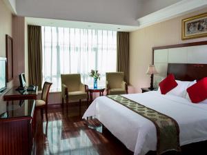 Pokój hotelowy z dużym łóżkiem i biurkiem w obiekcie Vienna Hotel Shenzhen Yousong Branch w mieście Bao'an