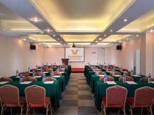 une salle de conférence avec des tables et des chaises ainsi qu'un podium dans l'établissement Vienna Hotel Guangzhou Dekang Road, à Canton