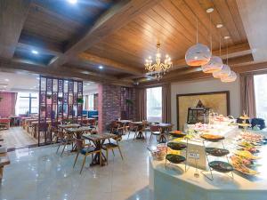 XifuにあるVienna Hotel Shandong Qingdao Chengyangのテーブルと椅子のあるレストラン、ビュッフェ