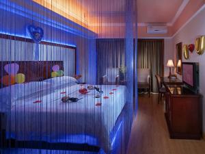 a hotel room with a bed with a blue curtain at Vienna Hotel Shenzhen Aiguo Road in Shenzhen