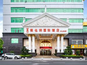 a building with a car parked in front of it at Vienna Hotel Dongguan Hengli Zhongshan Road in Hengli