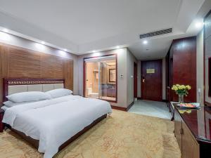 um quarto grande com uma cama grande e uma casa de banho em Vienna Hotel Kunming North Caiyun Road Asia em Kunming