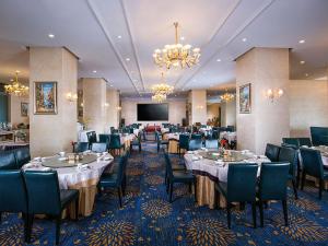 a dining room with tables and chairs and a projection screen at Venus Royal Hotel Guilin Airport in Guilin