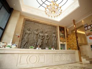 two people sitting at a counter in a hotel lobby at Vienna Hotel Jiangsu Kunshan Exhibition Center in Kunshan