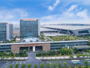 Vienna International Hotel Hangzhou East Railway Station في هانغتشو: اطلالة جوية على مبنى كبير مع موقف للسيارة