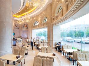 深圳维也纳酒店深圳光明光侨路田寮店的一间餐馆,里面的人坐在桌子上