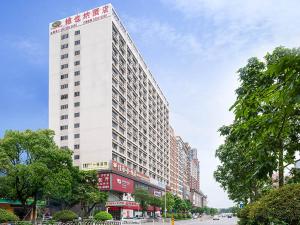 宝安にあるVienna Hotel Shenzhen Songgang Liye Roadの街路にある背の高い白い建物