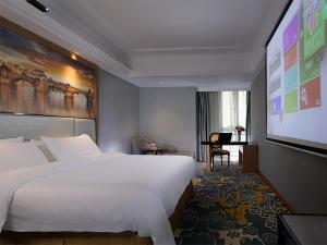 een hotelkamer met een groot bed en een projectiescherm bij Vienna Hotel Dongguan East Bus Station in Dongguan