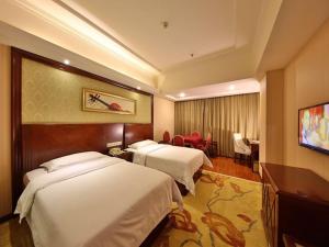 張家界市にあるVienna Hotel Zhangjiajie North Railway Stationのベッド2台とテレビが備わるホテルルームです。