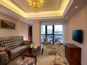 a living room with a couch and a television at Vienna Hotel Shunde Longjia Exhibition Center in Shunde +3 photos