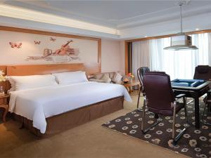 a hotel room with a large bed and a desk at Vienna International Hotel Foshan Beijiao New City Meidi Headquarter in Shunde