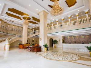 eine große Lobby mit einem Kronleuchter in einem Gebäude in der Unterkunft Vienna Hotel Heyuan High-Tech Yi Road in Heyuan