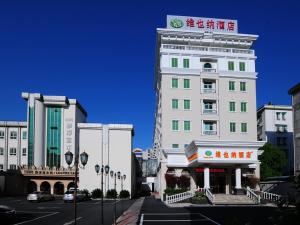 a tall white building with a sign on top of it at Vienna Hotel Hangzhou Yuhang Linping in Yuhang