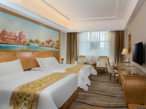 a hotel room with two beds and a television at Vienna Hotel Meizhou Jiangnan in Meizhou