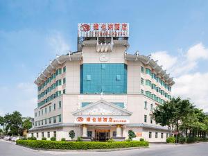 a large building with a sign on top of it at Vienna Hotel Huizhou Railway Station in Huizhou