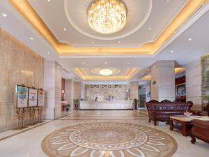 un grand hall avec un lustre et un grand tapis dans l'établissement Vienna International Hotel Guangzhou Railway Station, à Canton