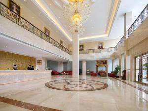 un gran vestíbulo con una lámpara de araña en el medio de un edificio en Vienna Hotel Dongguan Changping Avenue, en Dongguan