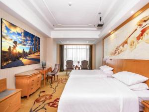 a hotel room with a large bed and a desk at Vienna Hotel Hunan Hengyang Railway Station in Hengyang