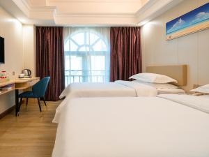 a hotel room with two beds and a desk at Vienna Hotel Zhuhai Xiangzhou Bus Station in Zhuhai