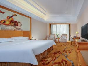 Vienna Hotel Chengdu Wenjiang Zhujiang Plaza tesisinde bir odada yatak veya yataklar