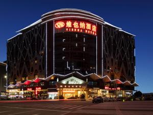 広州市にあるVienna Hotel Guangzhou Baiyun Airportの赤い看板が貼られた大きな建物