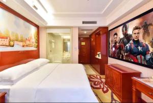 a bedroom with a captain america poster on the wall at Vienna Hotel Shenzhen Baoneng City Plaza in Longgang