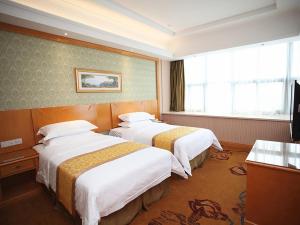 a hotel room with two beds and a television at Vienna Hotel Jiangsu Kunshan Exhibition Center in Kunshan