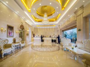 a large lobby with white furniture and a gold ceiling at Vienna Hotel Shunde Longjia Exhibition Center in Shunde