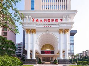 Vienna Hotel Yangjiang Jiangcheng District في يانغجيانغ: مبنى ابيض كبير وقوس في مدينة