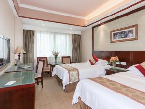 a hotel room with two beds and a television at Vienna International Hotel - Hangzhou Wulin Square Branch in Hangzhou