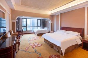 宝安にあるVienna Hotel Shenzhen Songgang Liye Roadのベッド2台とテレビがあるホテルの部屋