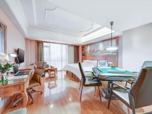 a hotel room with a bed and a table and chairs at Vienna Hotel Wuhan Yellow Crane Tower in Wuhan