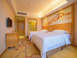 Un pat sau paturi într-o cameră la Vienna 3 Best Hotel Luoding Chuangyue Building