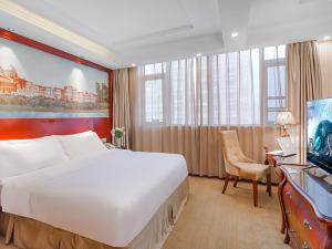 Vienna Hotel Jiangsu Shuyang Middle Renmin Road في Shuyang: غرفه فندقيه سرير كبير وتلفزيون