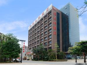 um grande edifício com escrita vermelha na lateral em Vienna Hotel Shenzhen Buji Ganli Road em Longgang