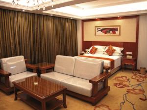 PingliangにあるVienna Classic Hotel Kongtong Avenueのベッド、ソファ、椅子が備わるホテルルームです。