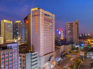 合肥市にあるVienna Hotel Anhui Hefei Sanxiaokouの高い建物の上に看板が立っている