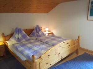 una camera con letto in legno e cuscini viola di Haus Melody a Filzmoos
