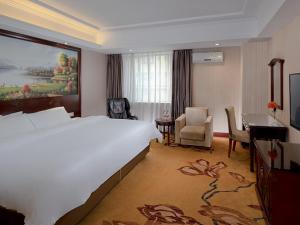 a hotel room with a large bed and a desk at Vienna Hotel Dongguan Chang'an Mid Zhen'an Road in Dongguan