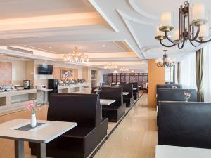 a restaurant with black chairs and tables and a counter at Vienna Hotel (Huizhou Daya Bay Xinyi Store) in Huizhou