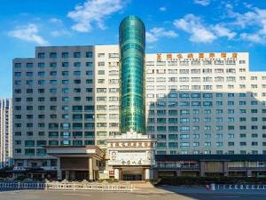 a green pole in front of a large building at Vienna International Hotel - Hangzhou Wulin Square Branch in Hangzhou