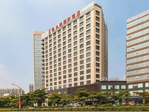 un edificio alto con un cartel encima en Vienna International Hotel Dongguan Chang'an North Station, en Dongguan