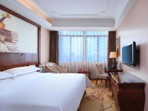 a hotel room with a large bed and a television at Vienna Classic Hotel Nanchang Jiefang West Road in Nanchang