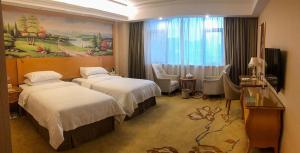 a hotel room with two beds and a television at Vienna International Hotel Puning International Commodity City in Puning