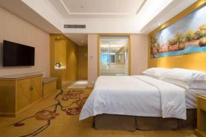 a bedroom with a large bed and a flat screen tv at Vienna Hotel Shenzhen Luofang in Shenzhen +3 photos