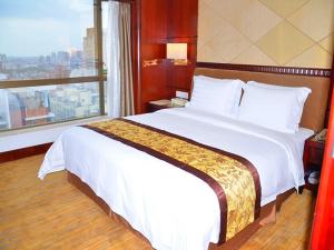 een groot bed in een hotelkamer met een raam bij Vienna International Hotel Dongguan Changping Swan Lake Road in Dongguan